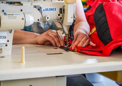 Iemand van het Werkbedrijf Eemsdelta maakt iets op de naaimachine